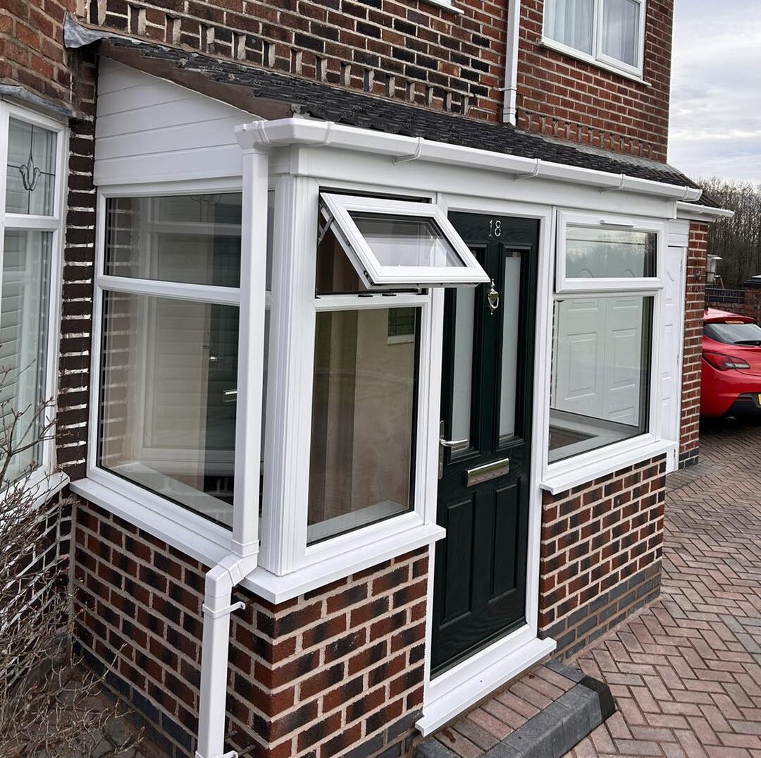 A brick house featuring a white door and a green door, showcasing a charming and inviting exterior.